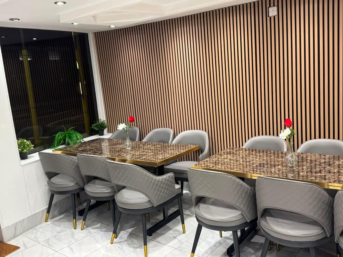 Spacious Dining Area with Marble Tables & Warm Slat Wood Walls